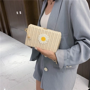 Pochette rectangulaire en paille avec marguerite blanche et anse corde sur costume bleu