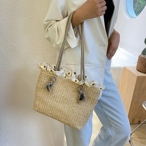 Large straw tote bag with sunflower ruffle trim and woven shoulder straps on model
