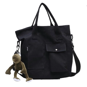 Minimalist black canvas tote bag with adjustable shoulder strap and cute plush toy charm