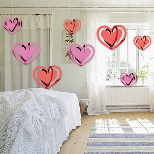 Close-up of 3D layered hollow heart hanging decorations in vibrant red and soft pink tones