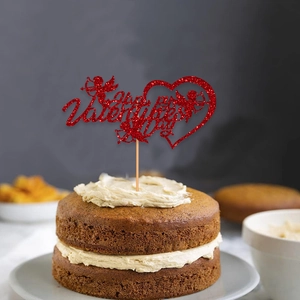 Macro detail of red glitter Happy Valentine's Day cake topper with Cupid and heart motif