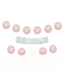 Detail of pink and silver glitter heart garland with Be Mine banner for party decor