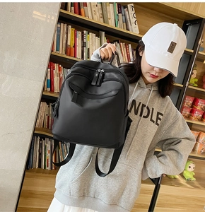 Détail du sac à dos en nylon noir avec fermetures éclair multicouches porté par le mannequin