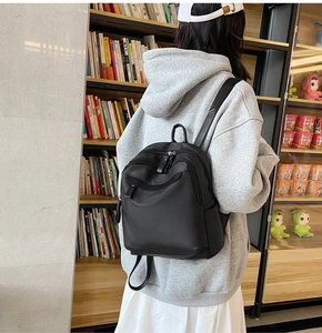 Détail d'un sac à dos noir minimaliste avec bretelles réglables et tissu imperméable