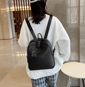 Vue détaillée du dos d'un sac à dos noir en nylon imperméable avec plusieurs poches zippées