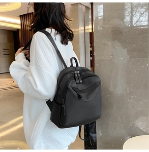 Sac à dos en nylon noir minimaliste porté par un mannequin dans un cadre moderne