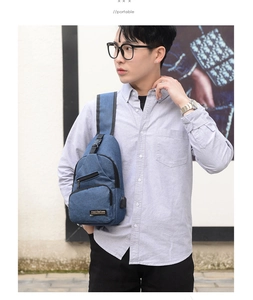 Close-up of blue men chest bag showing the USB charging port and denim texture