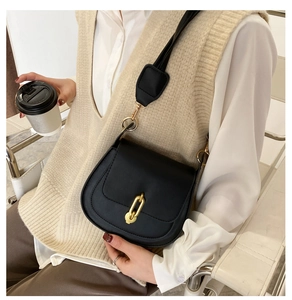Dettaglio della borsa a tracolla in pelle nera opaca con elegante chiusura a catena oro