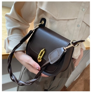 Dettaglio di una borsa a sella marrone cioccolato vintage con chiusura dorata