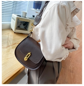 Dettaglio ravvicinato della borsa a sella vintage marrone con fibbia dorata a forma di U