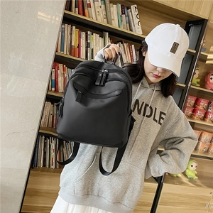 Sac à dos minimaliste en nylon noir avec plusieurs poches et bretelles sur modèle