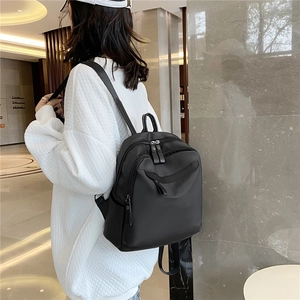 Sac à dos noir minimaliste pour femme en nylon avec plusieurs compartiments zippés