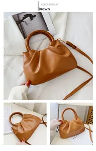 Detail of a brown pleated cloud bag featuring round wooden handles and fine texture