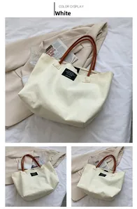Dettaglio della borsa tote in tela bianca con manici in finta pelle marrone e logo