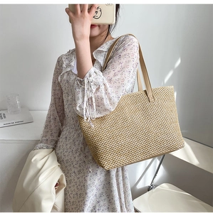 Straw tote bag with faux leather straps shown with floral dress for summer vacation
