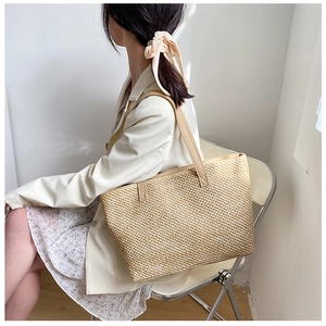Large woven tote bag with brown leather handles shown with model for scale and style