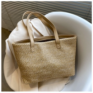 Detail of woven beige tote bag texture and reinforced faux leather shoulder straps