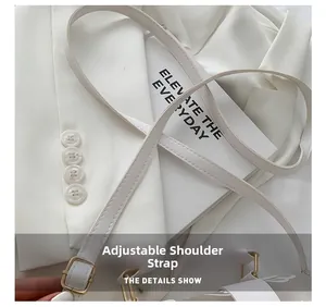 Close-up of adjustable white PU shoulder strap with gold metal buckle on a handbag