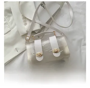Detailed top view of transparent PVC mini bag with white graffiti and gold twist lock