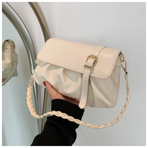 Detalle de bolso nube plisado beige con correa tejida y cierre de hebilla metálica