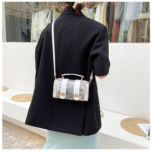 Detail of transparent graffiti crossbody bag with golden metal twist locks and white strap