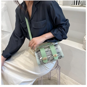 Detail of transparent PVC crossbody bag with graffiti print and light green handle