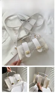 Detail of transparent jelly crossbody bag with white graffiti patterns and golden locks