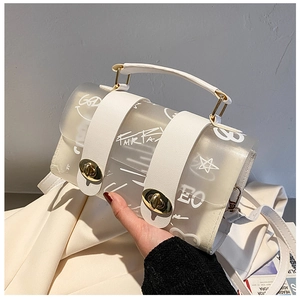 Close-up of white translucent jelly handbag with graffiti print and gold metal locks