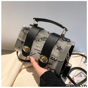Close-up of transparent grey PVC handbag with graffiti print and gold turn-lock closure