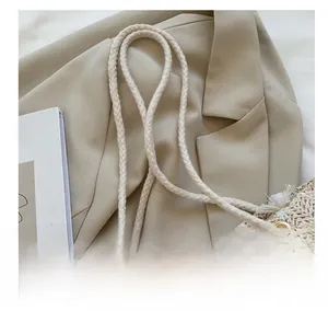 Detail der Stroh-Handtasche mit Blumenapplikationen und geflochtenen Baumwollgriffen