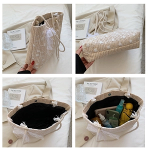 Detail von Spitzenschleife und Blumenstickerei an einer großen beigen Strohtasche