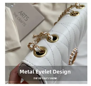 Vue détaillée du sac en cuir matelassé blanc avec œillets métalliques dorés et chaîne