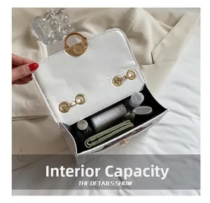 Capacité interne du sac à chaîne blanc montrant une batterie externe et des cosmétiques