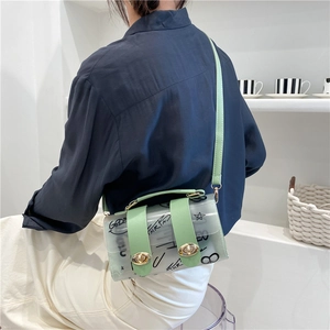 Green translucent jelly crossbody bag with graffiti print and gold turn-lock closure