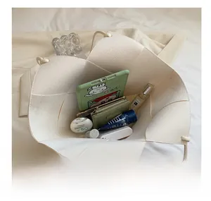 Top view showing large interior capacity of cream woven tote bag with daily essentials
