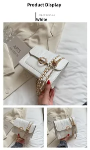 Détail du motif matelassé et boucle perle sur le sac bandoulière blanc en cuir