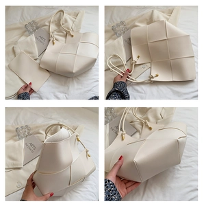 Detail of cream woven tote bag with matching inner pouch and gold hardware accents