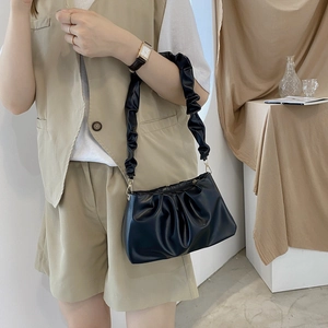 Minimalist black pleated cloud bag with stylish gathered strap shown on female model