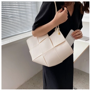 Close-up of white woven tote bag showing large leather weave and internal storage capacity