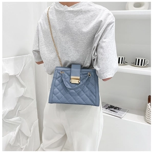 Détail du sac bandoulière en cuir matelassé bleu-gris avec chaîne dorée et fermoir