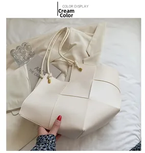 Detail of beige woven tote bag with oversized checkerboard pattern and knot handle