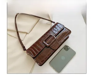Brown crocodile pattern baguette bag compared with a smartphone to show size details