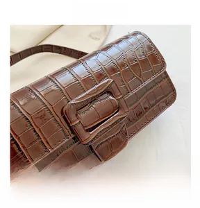 Close-up of vintage brown baguette bag with crocodile pattern and adjustable buckle