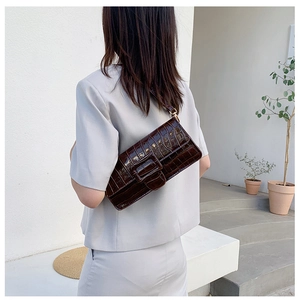 Close-up of retro brown crocodile pattern leather shoulder bag on model side profile