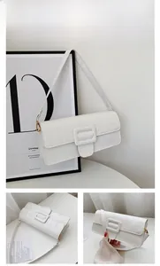 Detailed view of white crocodile pattern baguette bag with gold metal hardware