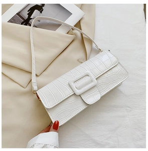 Macro shot of white crocodile texture faux leather bag with large square buckle detail