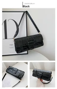 Detail of black crocodile pattern baguette bag with stylish square buckle and gold hardware