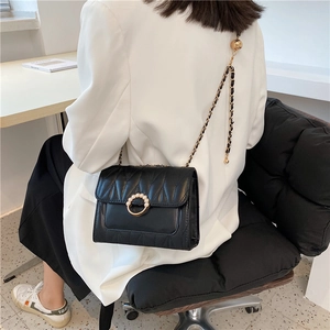 Chic black quilted crossbody bag with gold chain strap and pearl-encrusted buckle