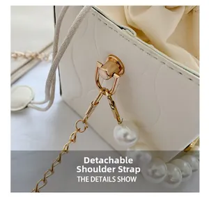 Close-up of quilted bucket bag featuring a pearl handle and detachable chain strap