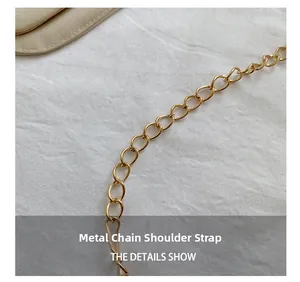 Detail of golden metal chain shoulder strap with polished oval links for handbag